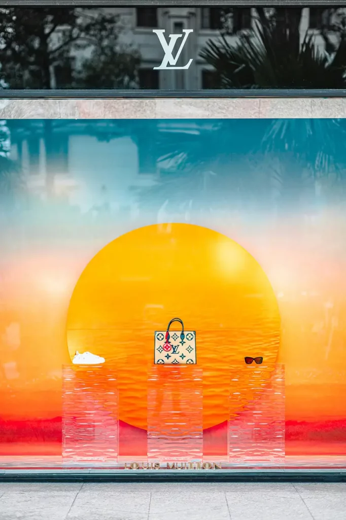 2025 window display trend featuring sensory design and minimalist atmosphere Contemporary Louis Vuitton window display with minimalist design and ambient lighting, an example of avant-garde window dressing trends 2025